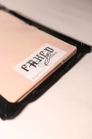 Close view of the Faked Skin label on the front of the product package